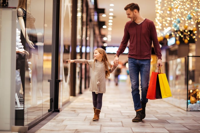 An adult and child in a shopping mall.