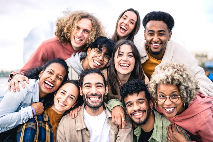 A group shot of about 10 young people clustered together and smiling.