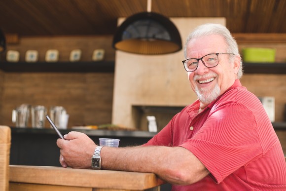 Someone in a red shirt is seated and smiling broadly.