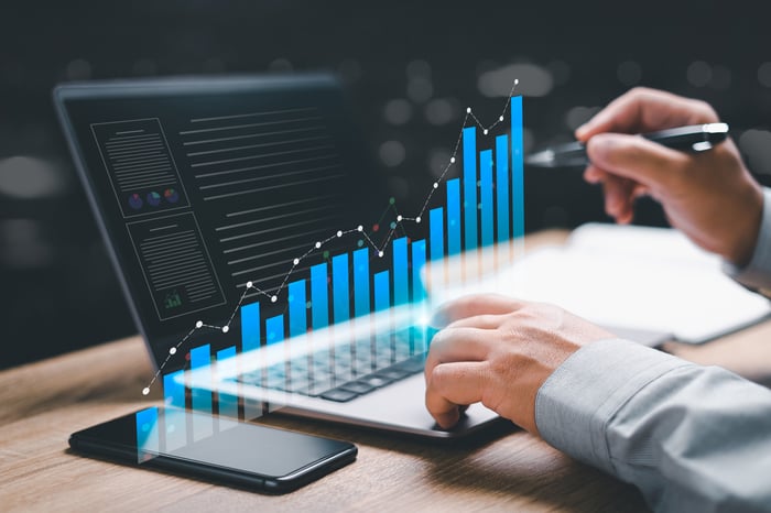 A rising chart virtually displayed on top of a laptop keyboard.
