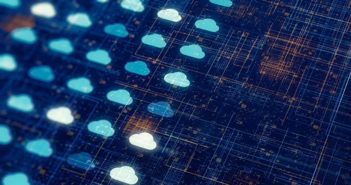 Digital cloud icons arranged on a dark circuit board background, symbolizing cloud computing and data networks.