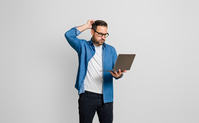 Confused investor with laptop.