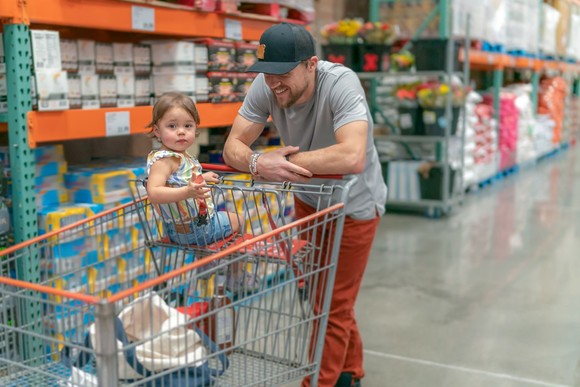 Person shopping with their child in a warehouse.