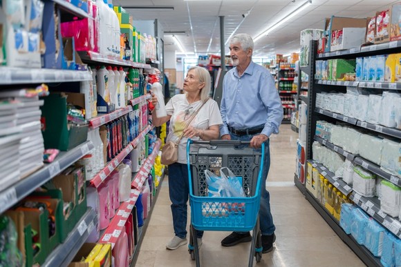 A couple shopping in a grocery aisle.