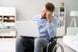 Person in wheelchair looking unhappy while wielding a laptop