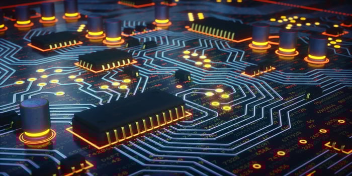 A circuit board with different colored light patterns coursing through it.