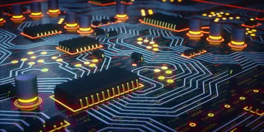 Abstract image featuring a circuit board with different colored light patterns coursing through.