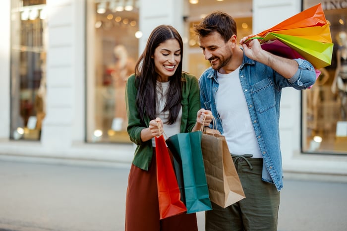 Two happy people with shopping bags. 