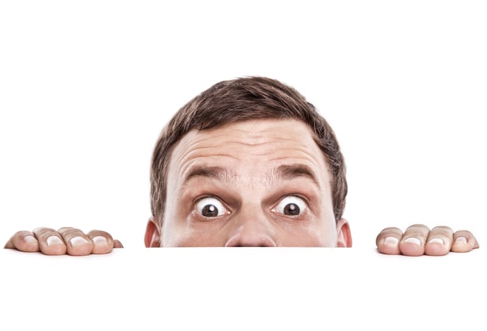 The top of someone's head is shown, peeking over a surface.