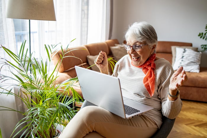 Excited person looking at laptop.