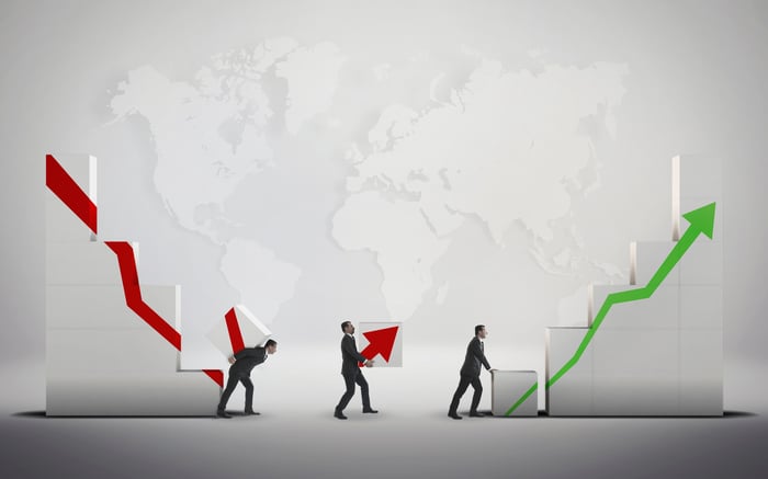 Small figures moving blocks to turn a downward arrow into an upward one.
