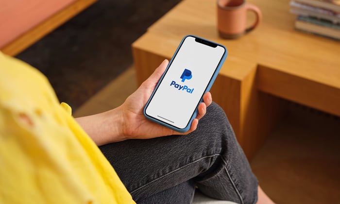Person holding phone with PayPal App.