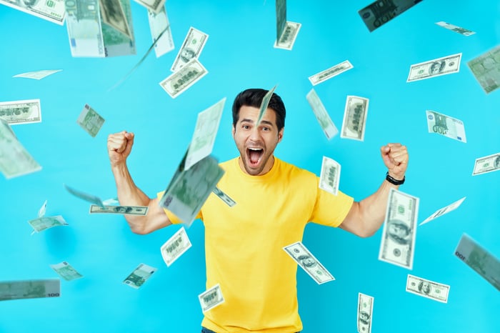 A happy person is showered with cash.