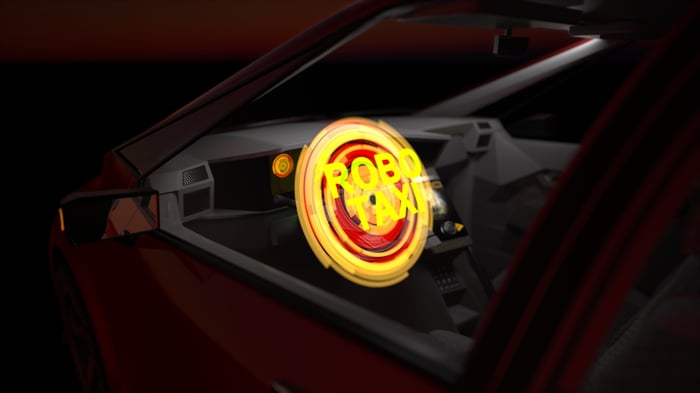 The word robotaxi illuminated inside a car.