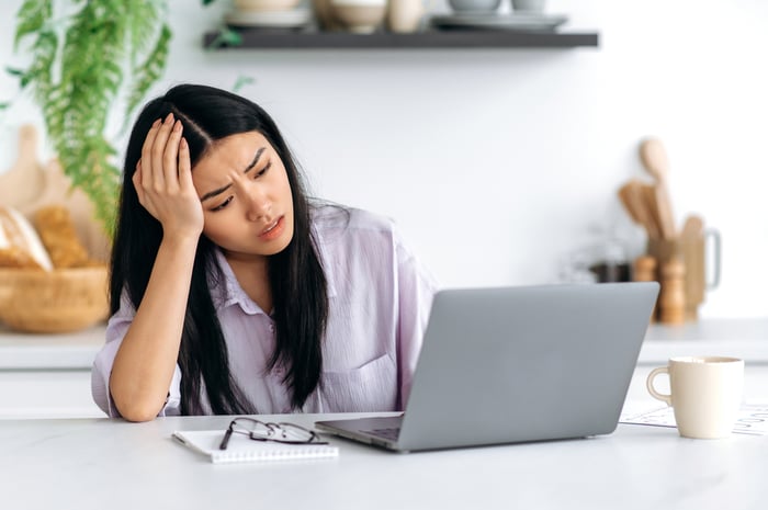 sad investor working on a laptop.