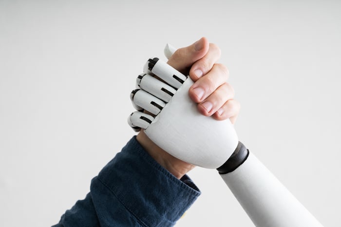 A human and a robot shaking hands.