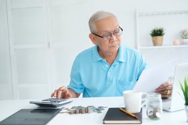 senior man document laptop calculator GettyImages-1400536618