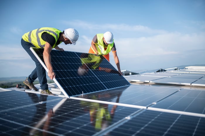 People work on solar panels.