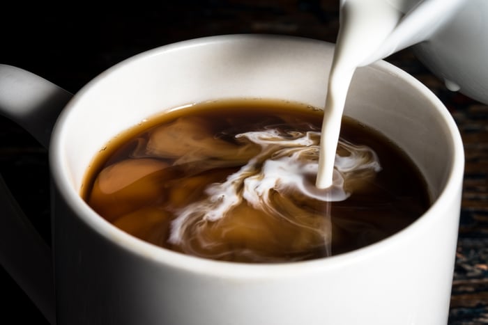 Milk or cream poured into a cup of coffee. 