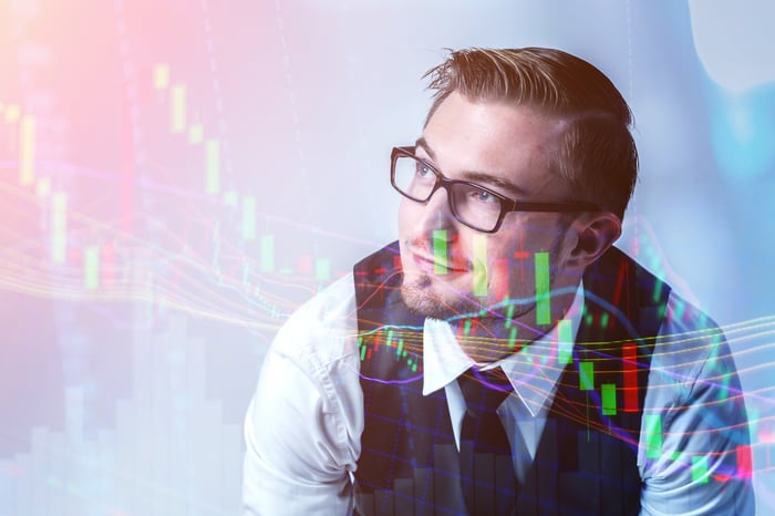A person smiling while looking at a stock chart.