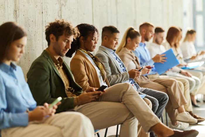 People sitting and looking at their phones.