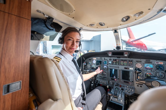 A pilot sitting in the cockpit looking back toward the cabin. 