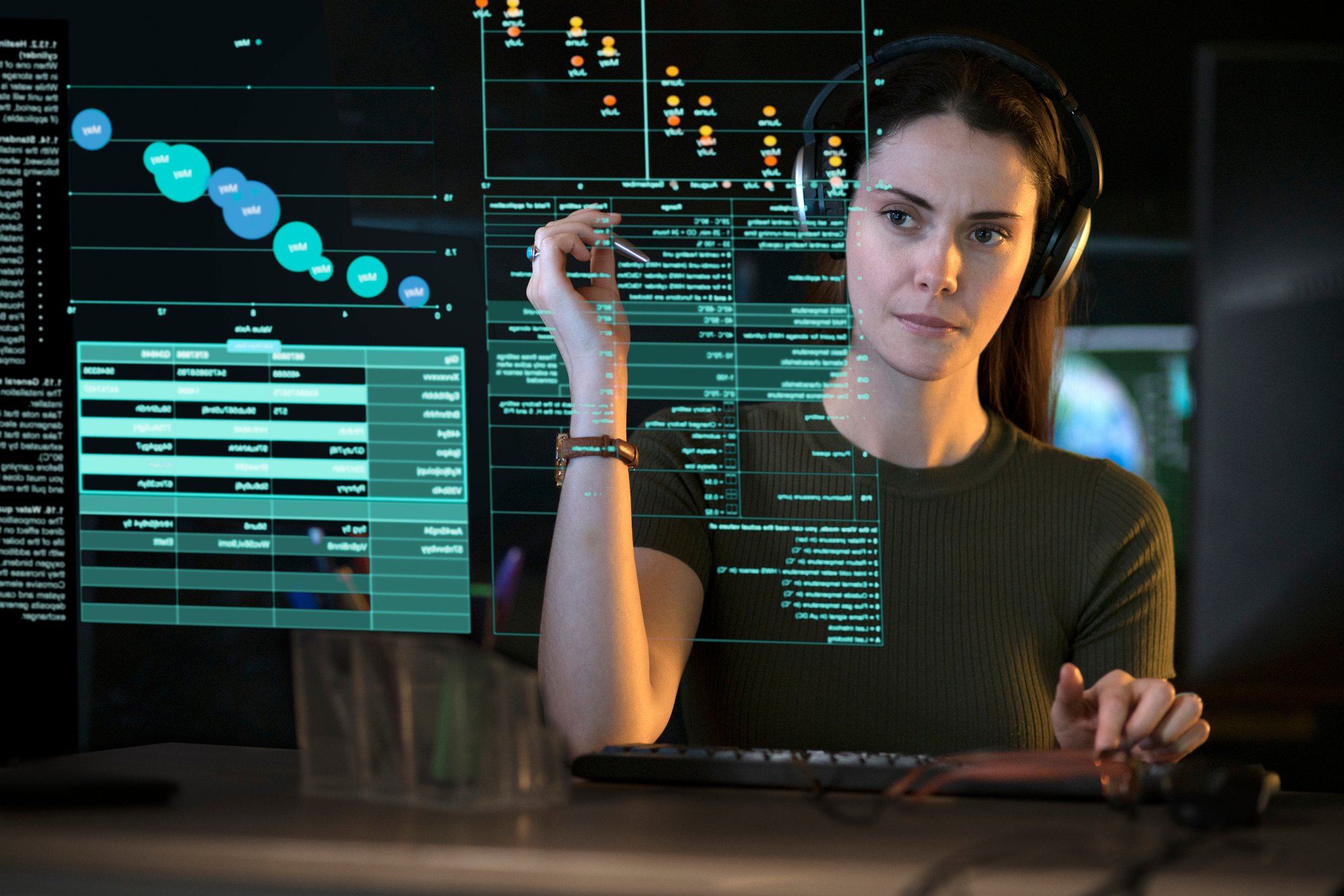 A person looking at graphs and data on a see-though computer display