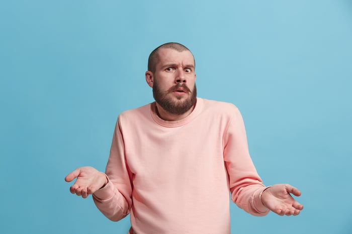 A person frowns and shrugs.