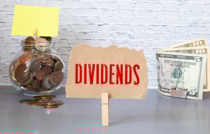 Small "dividends" signs standing up on a table front of cash.