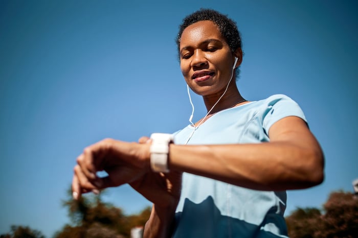 A woman checks her smartwatch