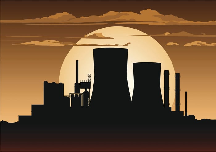 Drawing of a silhouette of a nuclear power plant against an orange sunset. 