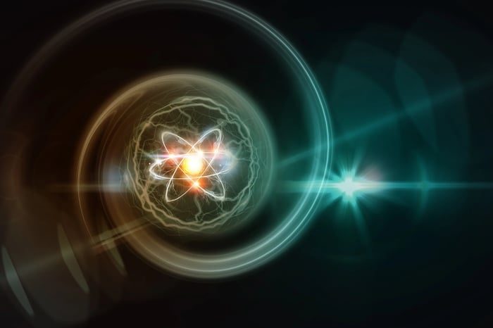 Atomic nucleus with electrons orbiting in a spiral pattern. 