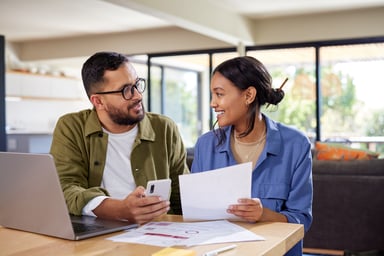 Smiling people holding documents and smartphone looking at each other