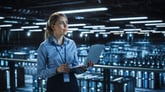 A person with a laptop surveying data center servers