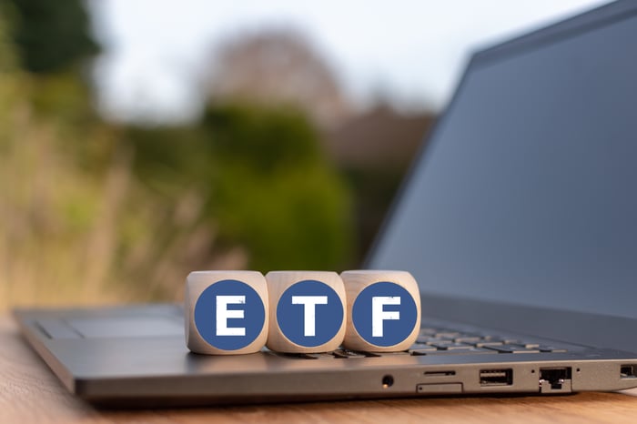 Three blocks with "ETF" written on them sitting on top of an open laptop.