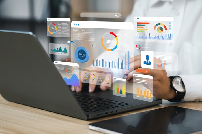 A person looking at charts on a laptop.