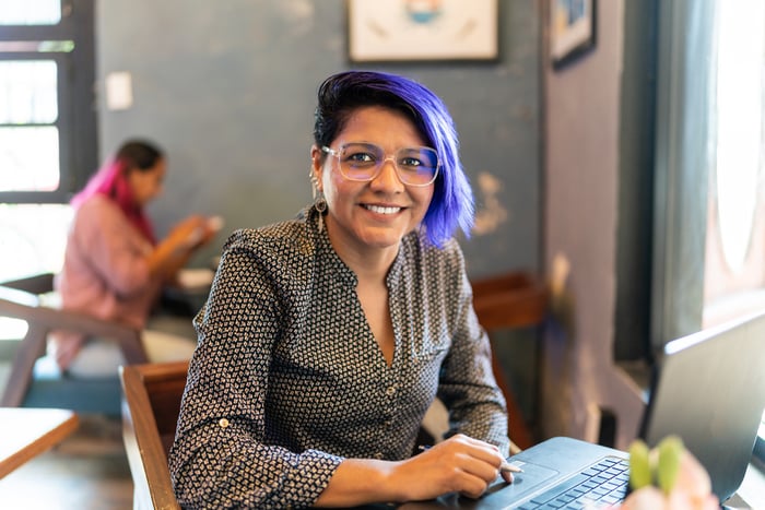 Smiling person working in a cafe setting.
