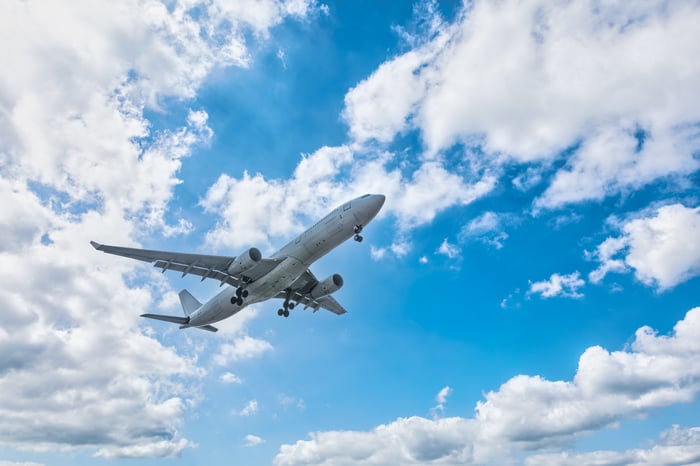 A passenger jet soars through the clouds.