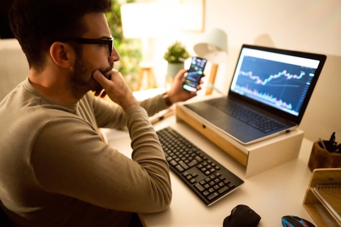 looking at chart on phone and laptop.