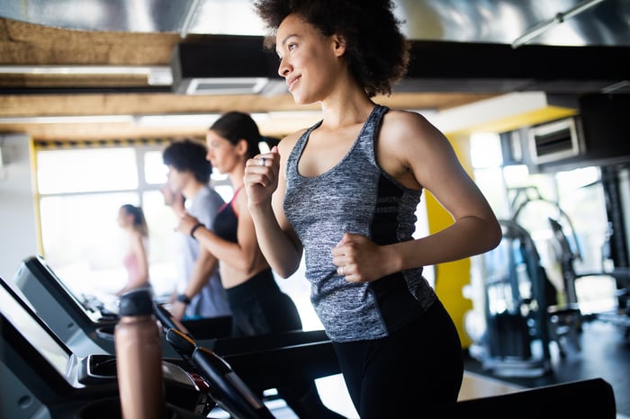 People running on treadmills at a gym.