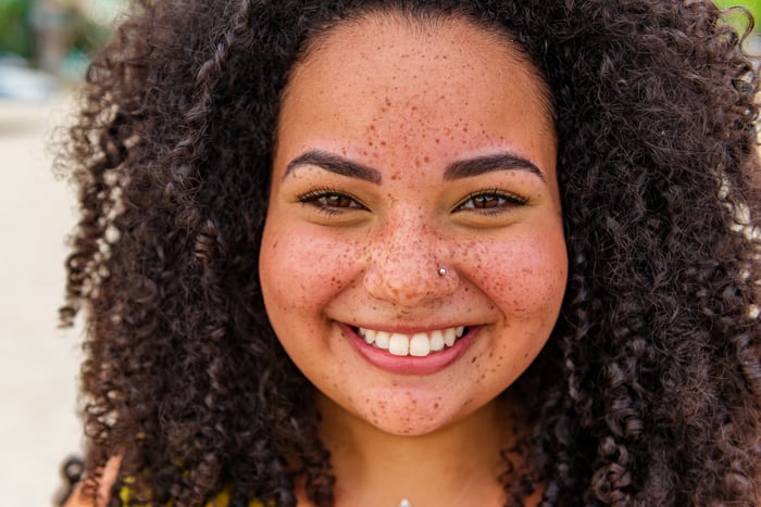 Someone with freckles is smiling broadly.