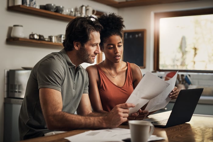 Two adults looking at financial paperwork. 