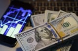 stock market graph smartphone hundred dollar bills money