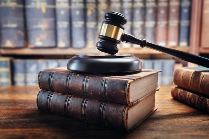 A judge's gavel on top of two leather-bound legal books. 