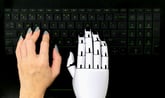 Human and robot hand on computer keyboard 1048873262