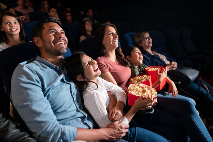 Adults and children in a movie theater.