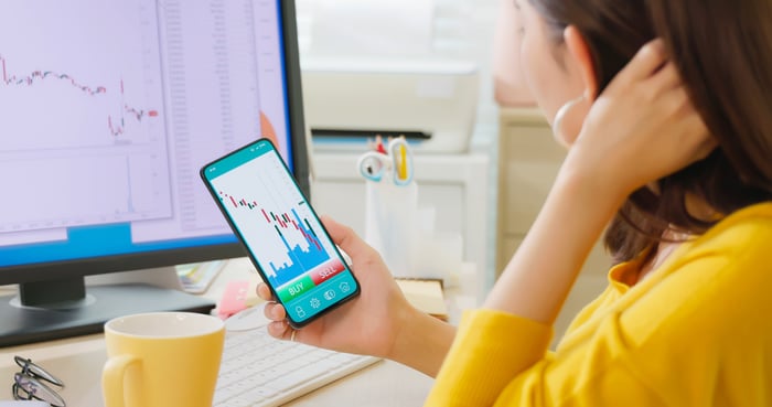 A person looks at a chart on their smartphone.