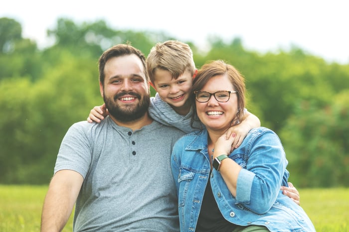 A three-person family is shown, smiling.