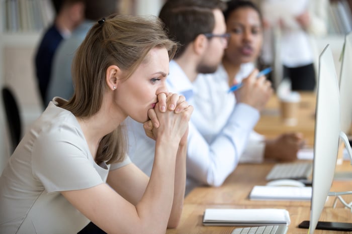 Stressed person sitting at a computer.