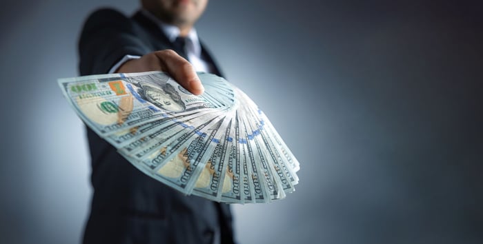 A person holding many bills.
